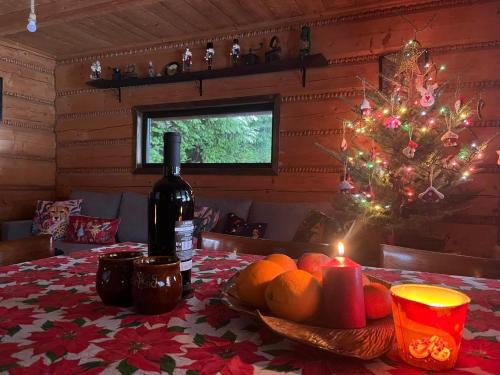 a table with a bottle of wine and a christmas tree at Chata pod lasem in Myślenice