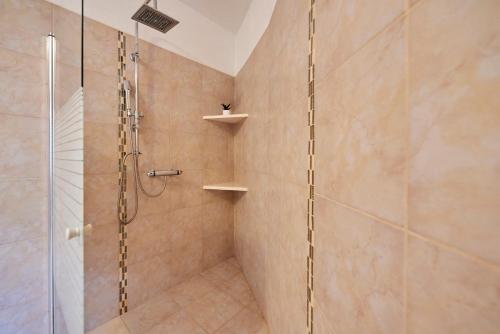a bathroom with a shower with a glass door at Palace Derossi in Trogir
