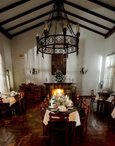a dining room with a table and a chandelier at Centro Vacacional Huaychulo in Concepción