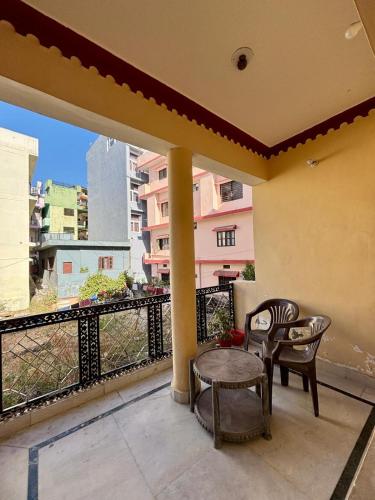 a balcony with a table and chairs and a view of a building at Prakruti Homestay in Rishīkesh
