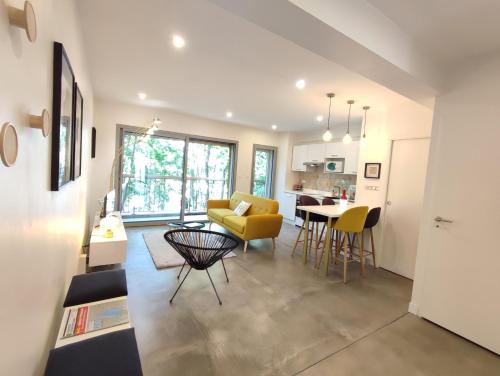 un salon avec un canapé jaune et une table dans l'établissement Proche Saint Sernin Magnifique T3 Wifi Clim Métro, à Toulouse