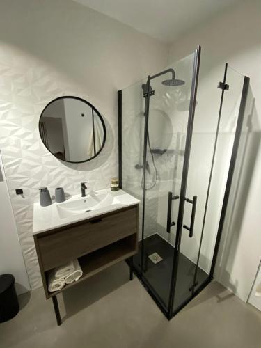 a bathroom with a sink and a shower with a mirror at Smart Residencial in Villanueva de la Cañada