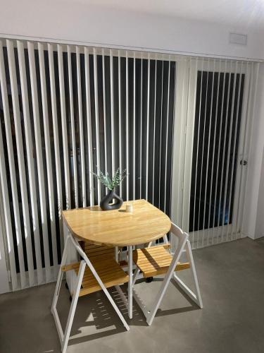 a table with a potted plant on it in front of a fence at Smart Residencial in Villanueva de la Cañada