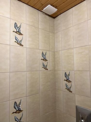 a tiled bathroom with birds on the wall at Turmfalke in Germaringen