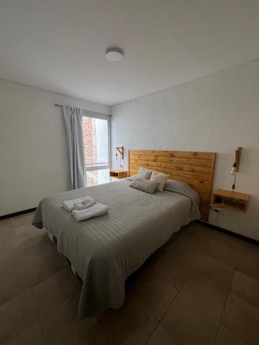a bedroom with a large bed with two towels on it at Duplex hasta 5 personas en hermosa zona T3 in Guaymallen