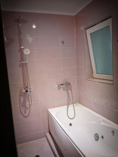 a pink bathroom with a tub and a shower at Apartment Andri in Yambol