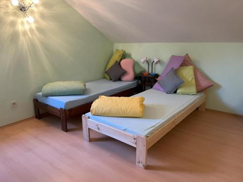 a room with two beds with colorful pillows on them at Turmfalke in Germaringen