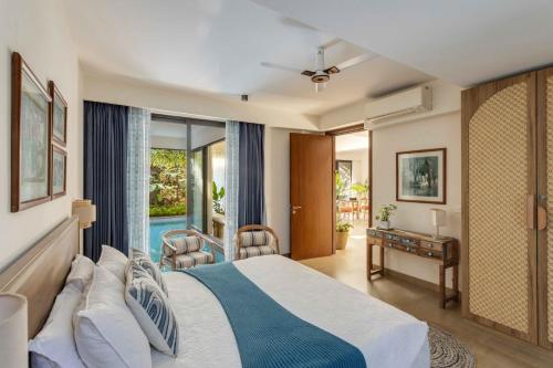 ein Schlafzimmer mit einem Bett und Blick auf einen Pool in der Unterkunft Casa 2565 by tisyastays in Anjuna