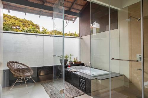 ein Badezimmer mit Glasdusche und Waschbecken in der Unterkunft Casa 2565 by tisyastays in Anjuna