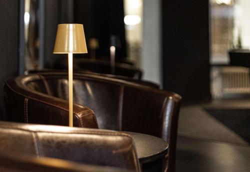 a table with a lamp in the middle of chairs at Best Western Hotel Arctic Eden in Kiruna