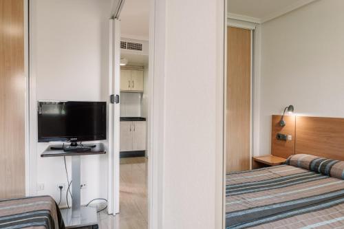 a hotel room with a bed and a television at Aparthotel Villas La Manga in La Manga del Mar Menor