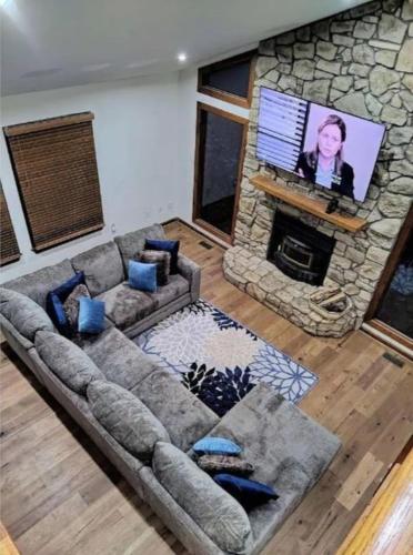 a living room with a couch and a stone fireplace at Cozy and Comfy with Lake Access in Mineral