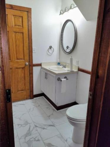 a bathroom with a toilet and a sink and a mirror at Cozy and Comfy with Lake Access in Mineral