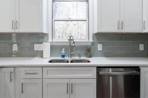 a white kitchen with a sink and a window at Cozy and Comfy with Lake Access in Mineral