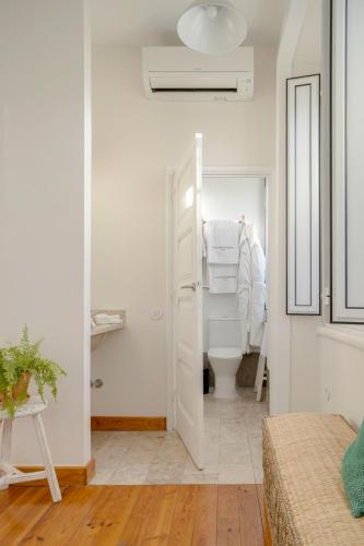 a white bathroom with a toilet in a room at Casa da Estefânea in Sintra