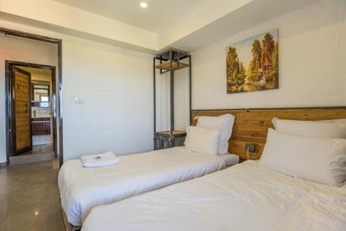 two beds in a room with white sheets at Villagio Resort in Zaarour in Zaarour