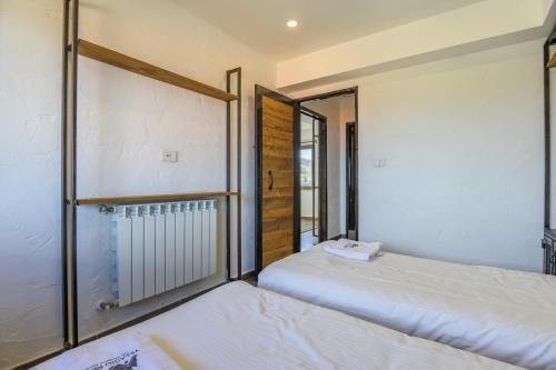 two beds in a room with a window at Villagio Resort in Zaarour in Zaarour