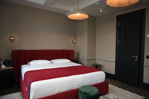 a bedroom with a bed with a red and white blanket at Hotel Retro in Batumi