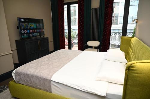 a bedroom with a bed and a couch and a television at Hotel Retro in Batumi