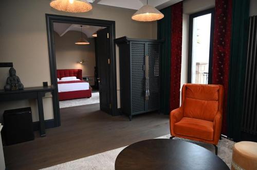 a bedroom with a bed and a chair and a table at Hotel Retro in Batumi