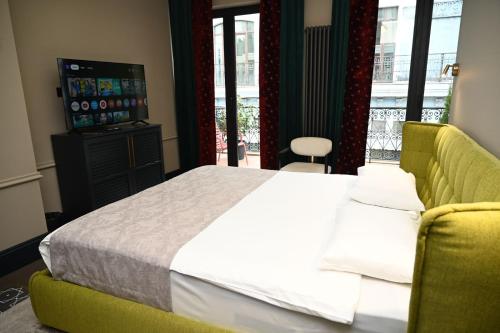 a bedroom with a bed and a couch and a television at Hotel Retro in Batumi