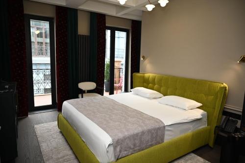 a bedroom with a large bed with a green headboard at Hotel Retro in Batumi