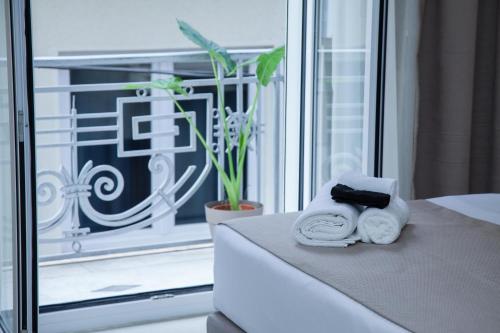 a bedroom with towels on a bed with a window at Athens Luxury center Aparts F&G in Athens