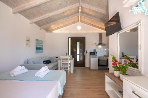 a living room with two beds and a kitchen at The Little White House in Koukounará