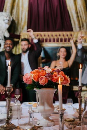 a table with a vase of flowers and a group of people at Delano Dubai at Bluewaters in Dubai