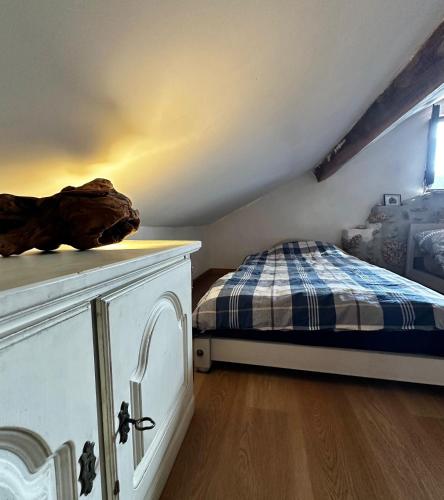 a bedroom with a bed and a dresser in a attic at Casa Trilho the Gaios in Tábua