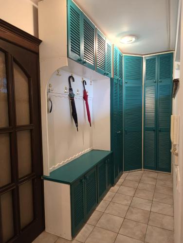 a hallway with green and white doors and a shelf with umbrellas at Dom blisko lotniska i Areny Tarczyńskiego in Wrocław