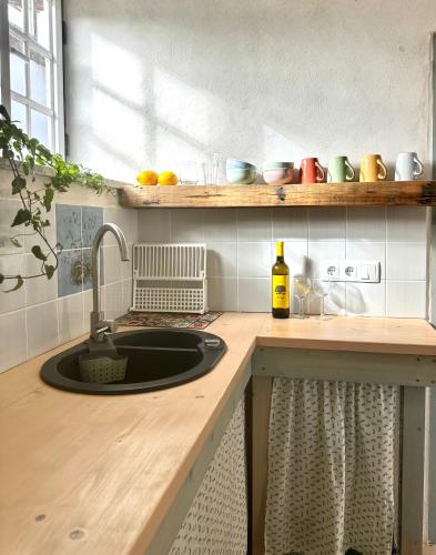a kitchen counter with a sink and a window at Casa Trilho the Gaios in Tábua