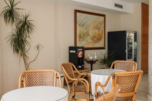 a room with two tables and chairs and a tv at Aparthotel Villas La Manga in La Manga del Mar Menor