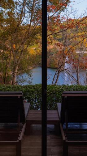 two benches in front of a window with a view of a river at 時地人 jijijin MATSUYAMA in Tobe