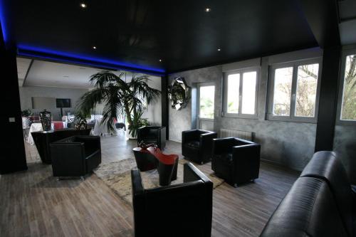 a waiting room with black leather chairs and tables at Hotel Air-lane in Saint-Léger-sous-Brienne