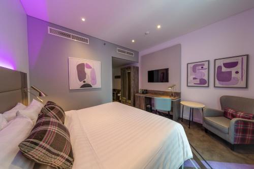 ドバイにあるPremier Inn Dubai Barsha Heightsのベッドと椅子付きのホテルルーム