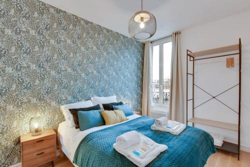 a bedroom with a bed with towels on it at Bluestay 141 - Superb apartment in Bagnolet