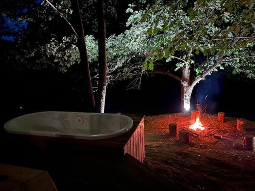 a bath tub sitting next to a camp fire at night at Syrok Magasflash in Sirok