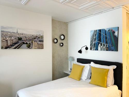 - une chambre avec un lit king-size et des oreillers jaunes dans l'établissement Appartement Seine et Marais, à Paris