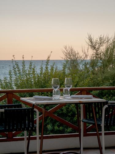 two wine glasses sitting on a table on a balcony at Hostal Empúries in L'Escala