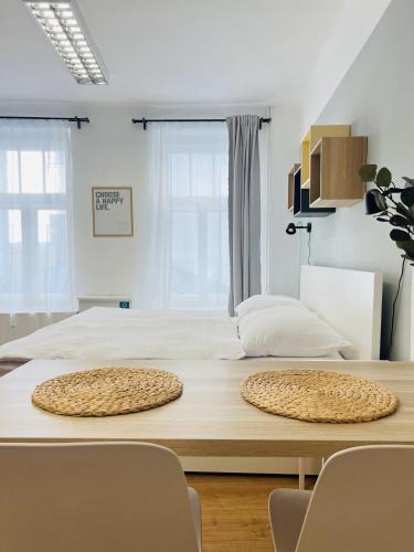 a table with two chairs and a bed in a room at 7nights Apartments Dominikánské naměstí in Brno