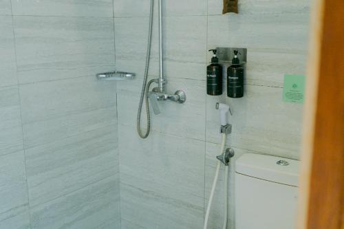 a bathroom with a shower with a shower head at Escape Bajo in Labuan Bajo