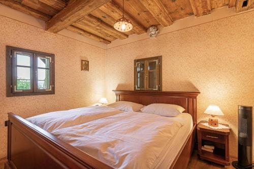 a bedroom with a large bed with a wooden headboard at Holiday home in Srednje Grcevje - Kranjska Krain 26095 in Srednje Grčevje