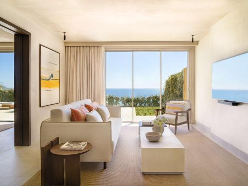 a living room with a couch and a flat screen tv at Fairmont La Hacienda Costa del Sol in Alcaidesa