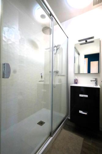a bathroom with a glass shower and a sink at Charmant appartement bord de mer in Dinard