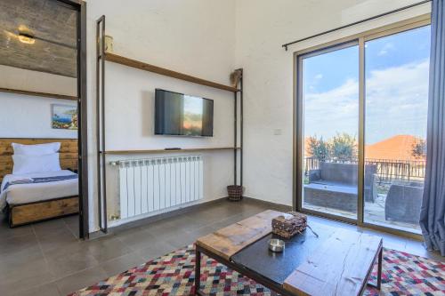 a living room with a bed and a large window at Villagio Resort in Zaarour in Zaarour