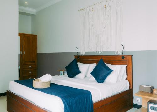 a bedroom with a large bed with blue and white pillows at Escape Bajo in Labuan Bajo