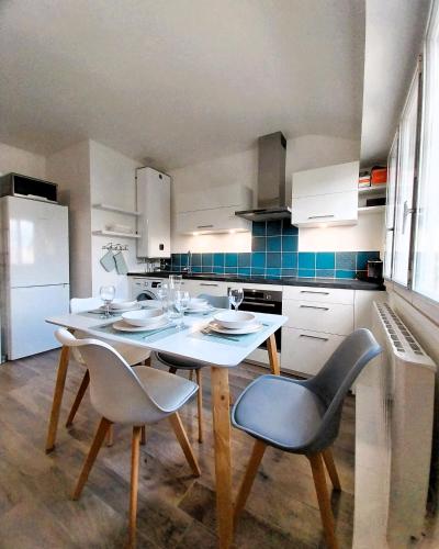 a kitchen with a table and chairs in a kitchen at Charmant appartement bord de mer in Dinard