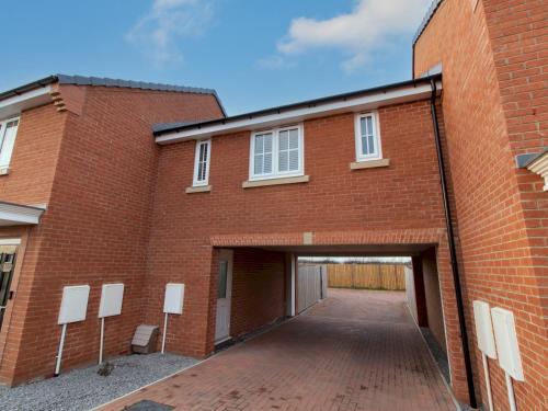 a red brick building with a garage at Charming Coastal Retreat - 1-Bedroom Flat in Blyth - Pass the Keys in Blythe