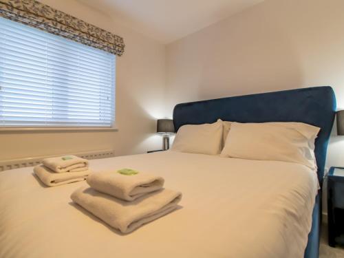 a bedroom with a bed with towels on it at Pass the Keys Charming Coastal Retreat – 1-Bedroom Flat in Blyth in Blythe